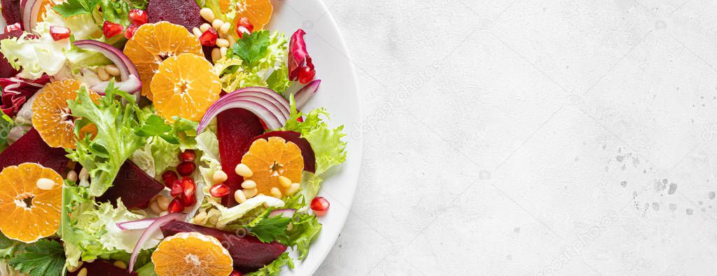 Christmas salad with boiled beet, red onion, tangerines, pomegranate, parsley, pine nuts and lettuce leaves, banner