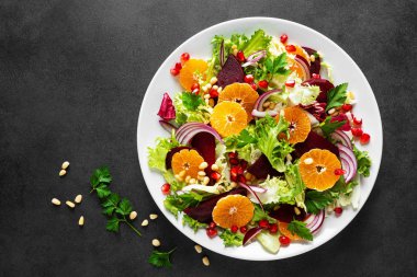 Haşlanmış pancar, kırmızı soğan, mandalina, nar, maydanoz, çam fıstığı ve marul yapraklı Noel salatası.