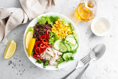 Taze salata yapraklı tavuk eti kasesi, mısır, salatalık, tatlı biber ve kinoa.