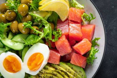 Ketogenik, paleo diyet kasesi tuzlanmış somon balığı, limon, avokado, zeytin, haşlanmış yumurta, salatalık, yeşil marul salatası ve chia tohumu, sağlıklı besin akımı, üst görünüm