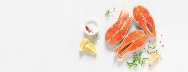 Somon balığı. Taze çiğ somon balığı bifteği, yemek malzemeleri, otlar ve limon beyaz arka planda, üst manzara, afiş