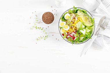 Kahvaltı yulaf lapası taze sebze salatası salatalık, turp, marul, mısır, avokado, chia tohumu ve haşlanmış yumurta. Sağlıklı dengeli yiyecekler. Üst Manzara. Düz yatıyordu