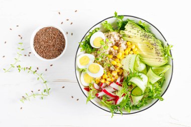 Kahvaltı yulaf lapası taze sebze salatası salatalık, turp, marul, mısır, avokado, chia tohumu ve haşlanmış yumurta. Sağlıklı dengeli yiyecekler. Üst Manzara. Düz yatıyordu