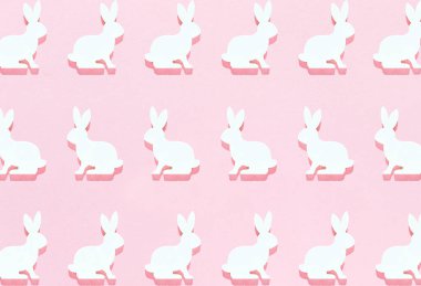 Paskalya beyaz tavşanı parlak pembe arka planda yatıyordu. Sert gölgeler, duvar kağıtları, tebrik kartları, üst hayat.