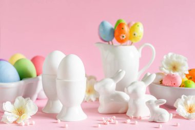 Pembe arka planda bahar çiçekleriyle Paskalya bayramı süsleri, bayram tebrik kartı.