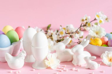 Pembe arka planda bahar çiçekleriyle Paskalya bayramı süsleri, bayram tebrik kartı.