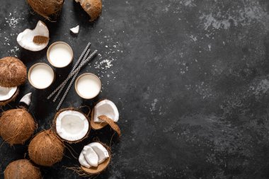 Hindistan cevizi sütü, siyah arka planda çatlak hindistan cevizi, üst manzara.