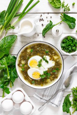 Yeşil kuş ve ıspanak çorbası haşlanmış yumurta ve ekşi krema beyaz ahşap ahşap masa, üst manzara
