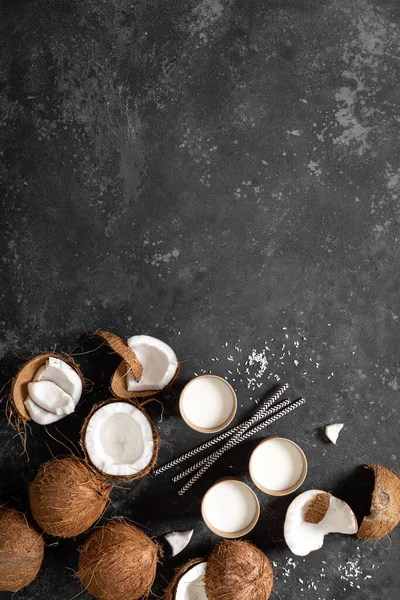 Kokosmilch Ganze Und Rissige Kokosnüsse Auf Schwarzem Hintergrund Draufsicht — Stockfoto