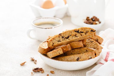 Kurutulmuş yaban mersinli bisküvi, ceviz ve bir fincan kahve. 