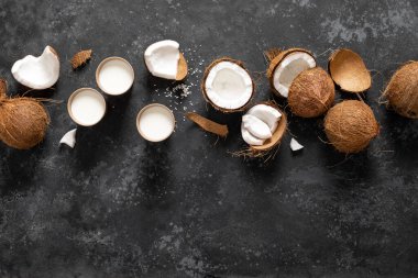 Hindistan cevizi sütü, siyah arka planda çatlak hindistan cevizi, üst manzara.