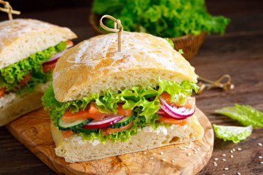 Ev yapımı ciabatta ekmeği, tuzlu somon balığı, peynir, salatalık, soğan ve taze marul salatası, İtalyan mutfağı.
