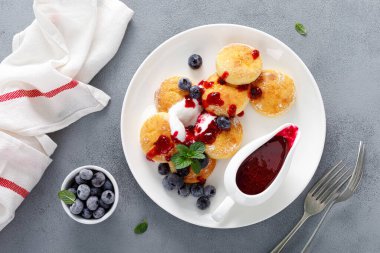 Pişmiş süzme peynirli krep, yoğurtlu şurup, yabanmersini sosu ve taze dut.