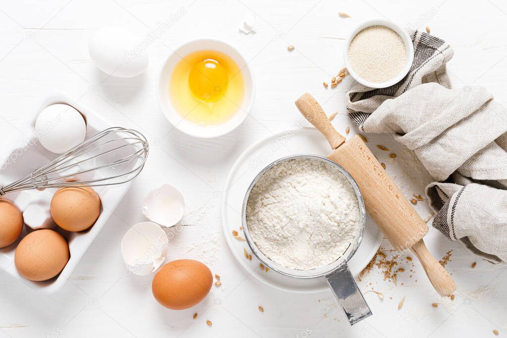 Baking homemade bread on white kitchen worktop with ingredients for cooking, culinary background, copy space, overhead view