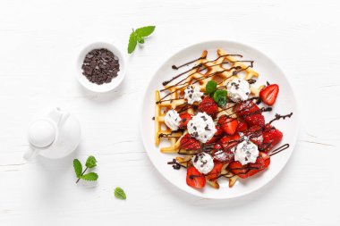 Taze çilekli Belçika waffle 'ı, çikolata soslu ve krem şantili.