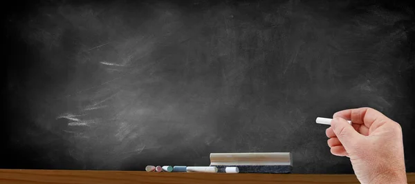 Hand and chalk next to blackboard — Stock Photo, Image