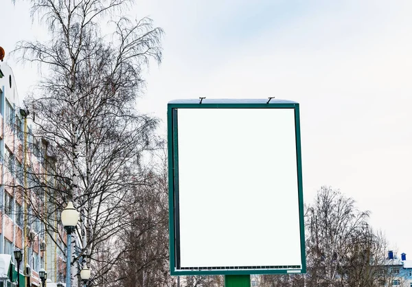 Blank Billboard on the street on the background trees and sky, winter urban landscape, mock up