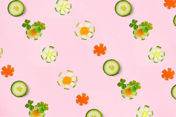 Colorful vegetables, food pattern, slices of raw cucumber and boiled carrots in the form of flowers on wooden background. The view from the top