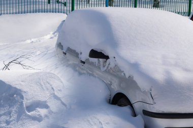 Araba kışın karla kaplı, güneş ışığında kar sürükleniyor, kış şehir manzarası