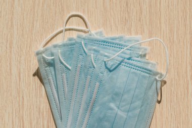 Grip ve diğer viral hastalıklardan korunmak için terapi maskesi. Virüsün yayılması ve salgına karşı ahşap bir arka planda koruyucu maske. Coronavirüs,