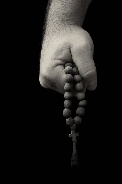 Rosary in male hands on a black background — Stock Photo, Image