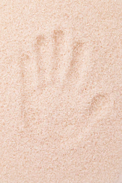 Handprint on white rice — Stock Photo, Image