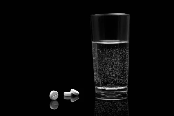 Drugs and a glass of water on a black background — Stock Photo, Image