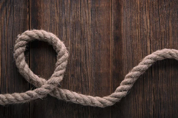 Thick twisted rope on a wooden background — Φωτογραφία Αρχείου