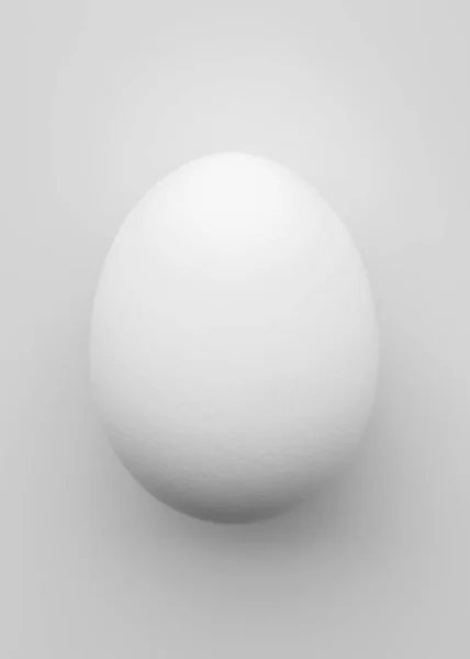 Huevo de pollo blanco sobre un fondo claro . — Foto de Stock