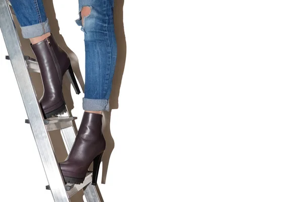 A girl on a stepladder in fashion shoes.