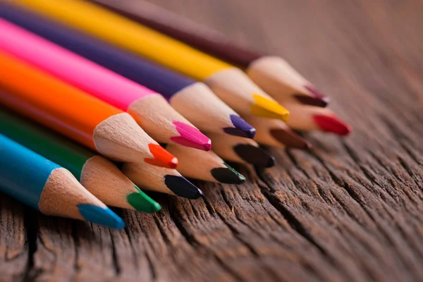 Ołówki kolorowe na drewnianym stole — Zdjęcie stockowe