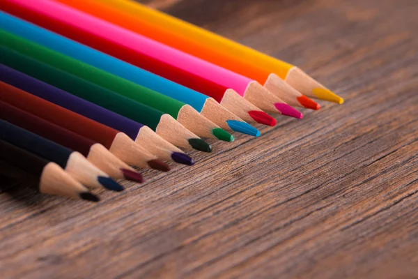 Ołówki kolorowe na drewnianym tle. — Zdjęcie stockowe