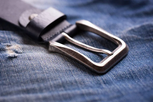 Un cinturón desabotonado descansa sobre una tela de mezclilla —  Fotos de Stock