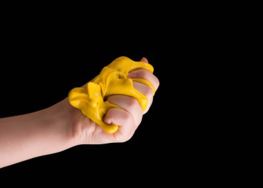 The child squeezes yellow slime in his hand. Game with slime. clipart