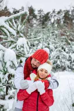 Bir çift bir kar ormanda sarılma