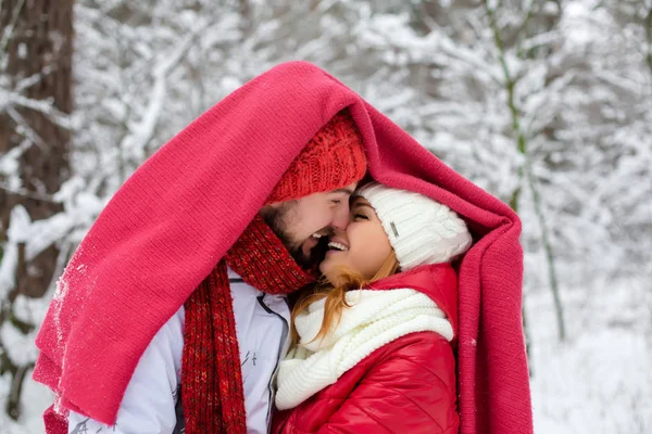 Una pareja parada debajo de una manta roja — Foto de Stock