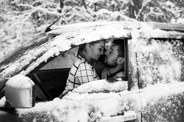 A couple sitting inside a snow