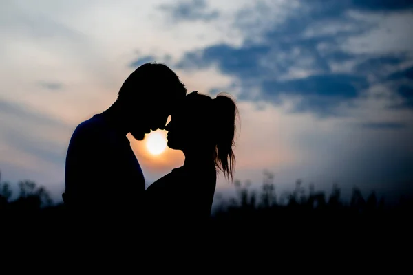Любящие пары обнимаются на закате — стоковое фото