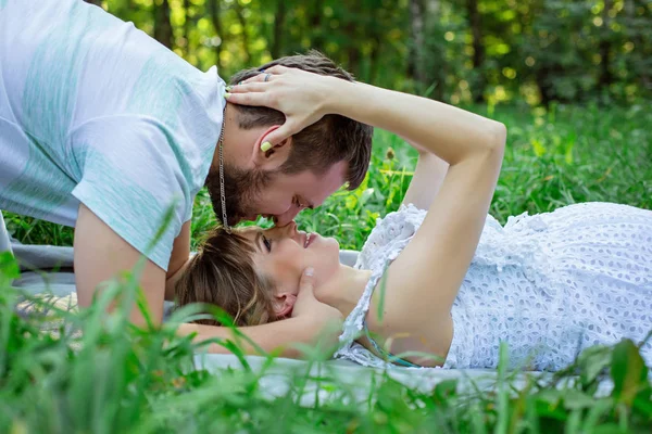 Man and  pregnant wife relaxing on grass — Stock Photo, Image