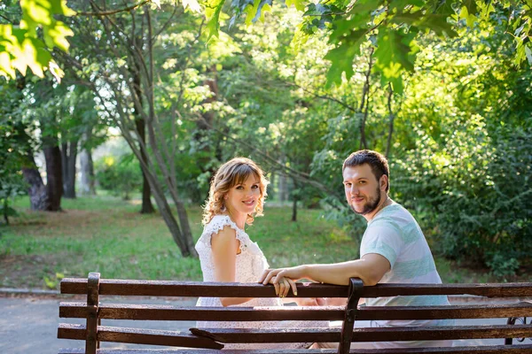 Mann und schwangere Frau sitzen auf Bank — Stockfoto