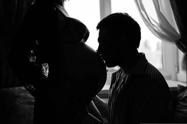 Мужчина целует животик жены — стоковое фото