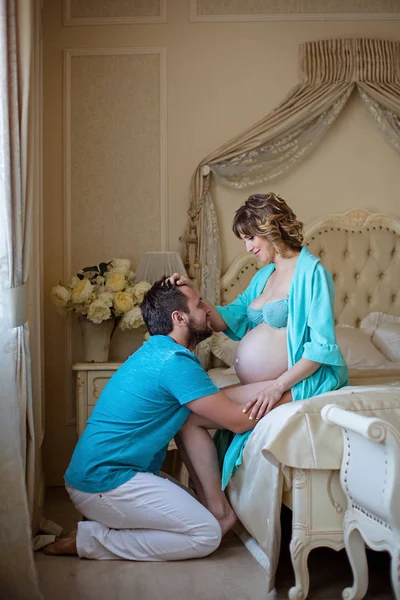 Man and  pregnant wife  on bed — Stock Photo, Image