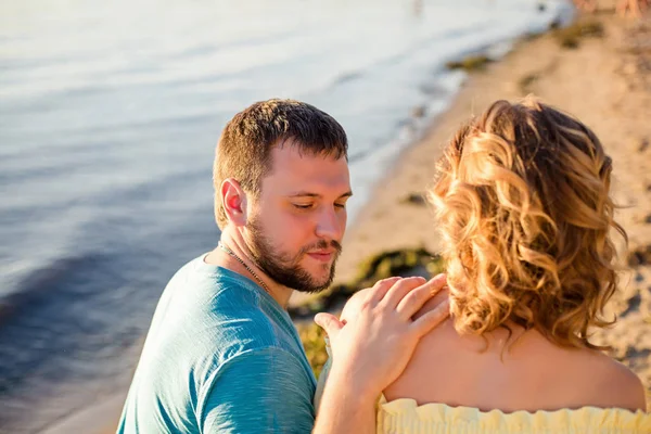 男人和妻子坐在海滩上 — 图库照片