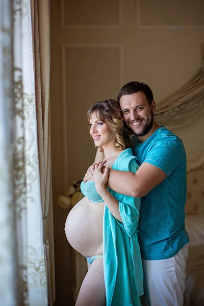 Hombre y esposa embarazada abrazos — Foto de Stock