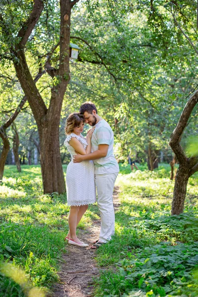 Mann und schwangere Frau umarmen sich im Park — Stockfoto