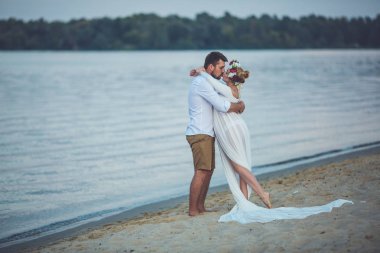 Yakışıklı delikanlı ve onun hamile eşi nehir sahilde öpüşme