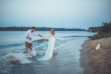 Yakışıklı delikanlı ve onun hamile eşi eğleniyor nehirde yaz akşamları