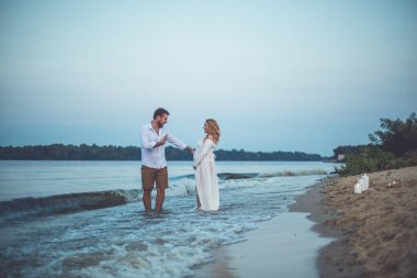 Yakışıklı delikanlı ve onun hamile eşi eğleniyor nehirde yaz akşamları