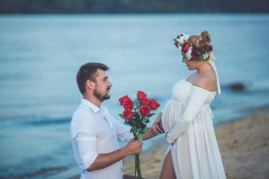 Yakışıklı delikanlı giwing gül onun hamile eşi için 