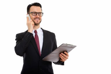 Genç ve mutlu iş adamının, panoyu tutarken gülümsediği ve cep telefonuyla konuştuğu bir stüdyo fotoğrafı.
